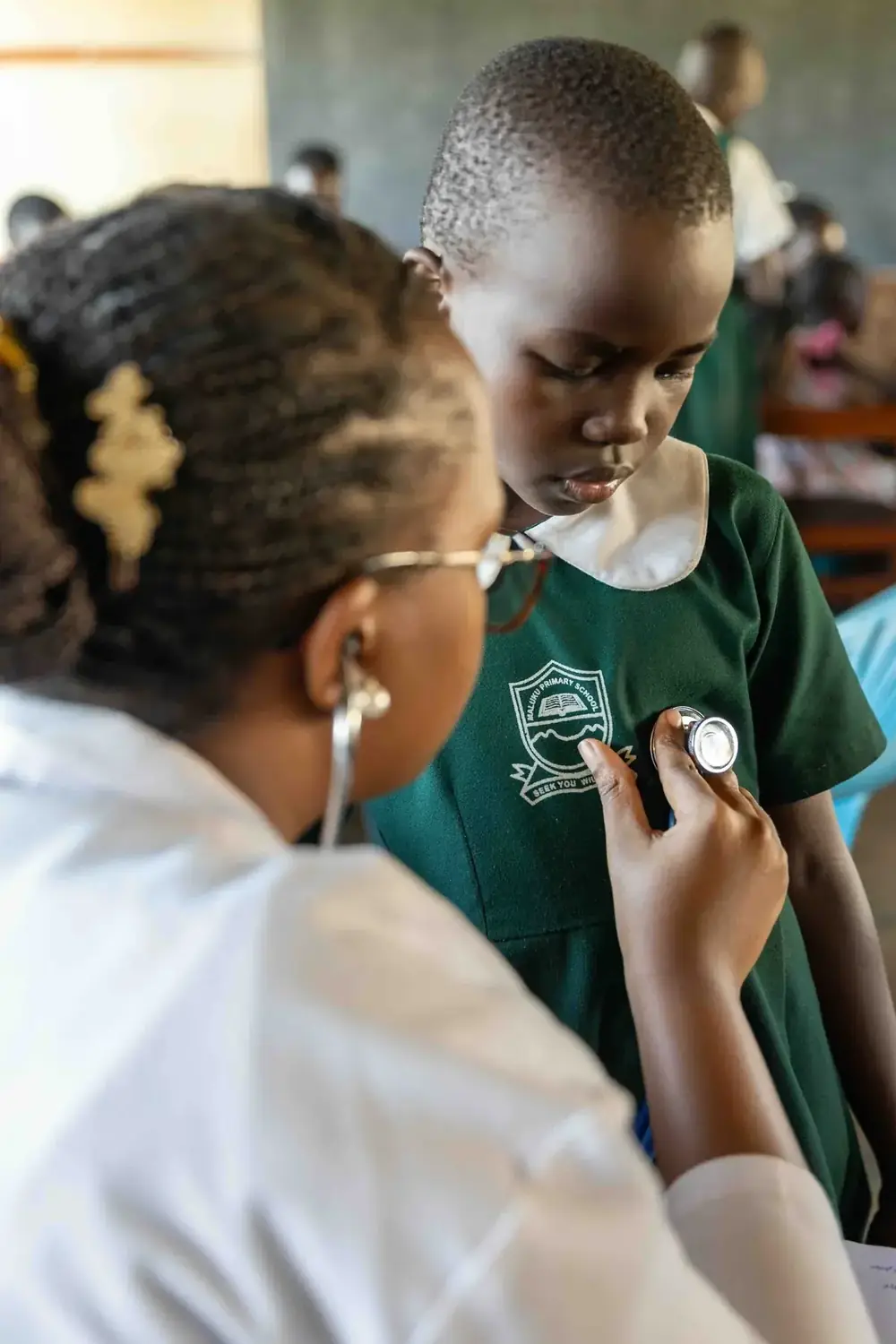 A clinician listens to a pupil’s chest during a school camp